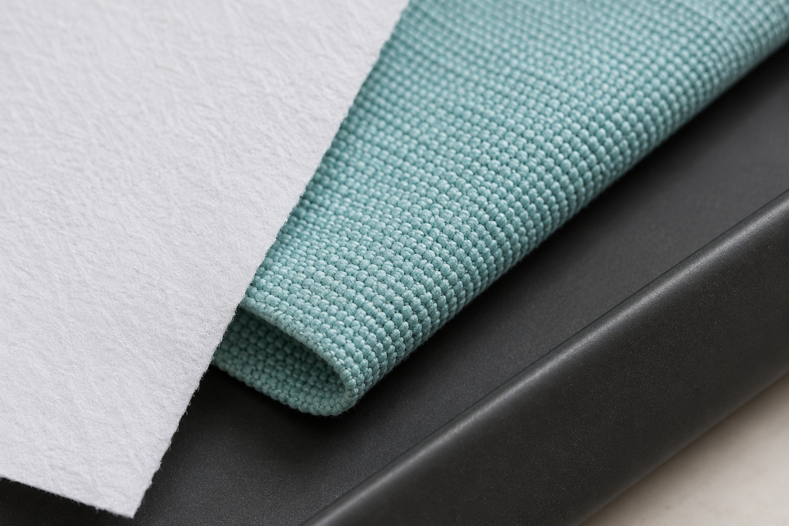 A clean tray edge, reusable mat corner, and plain paper edge show three maintenance surfaces.